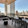 a patio with tables and chairs on it with a city skyline in the background
