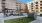 a courtyard with chairs and tables in front of a building