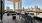 a patio with tables and chairs on it with a city skyline in the background